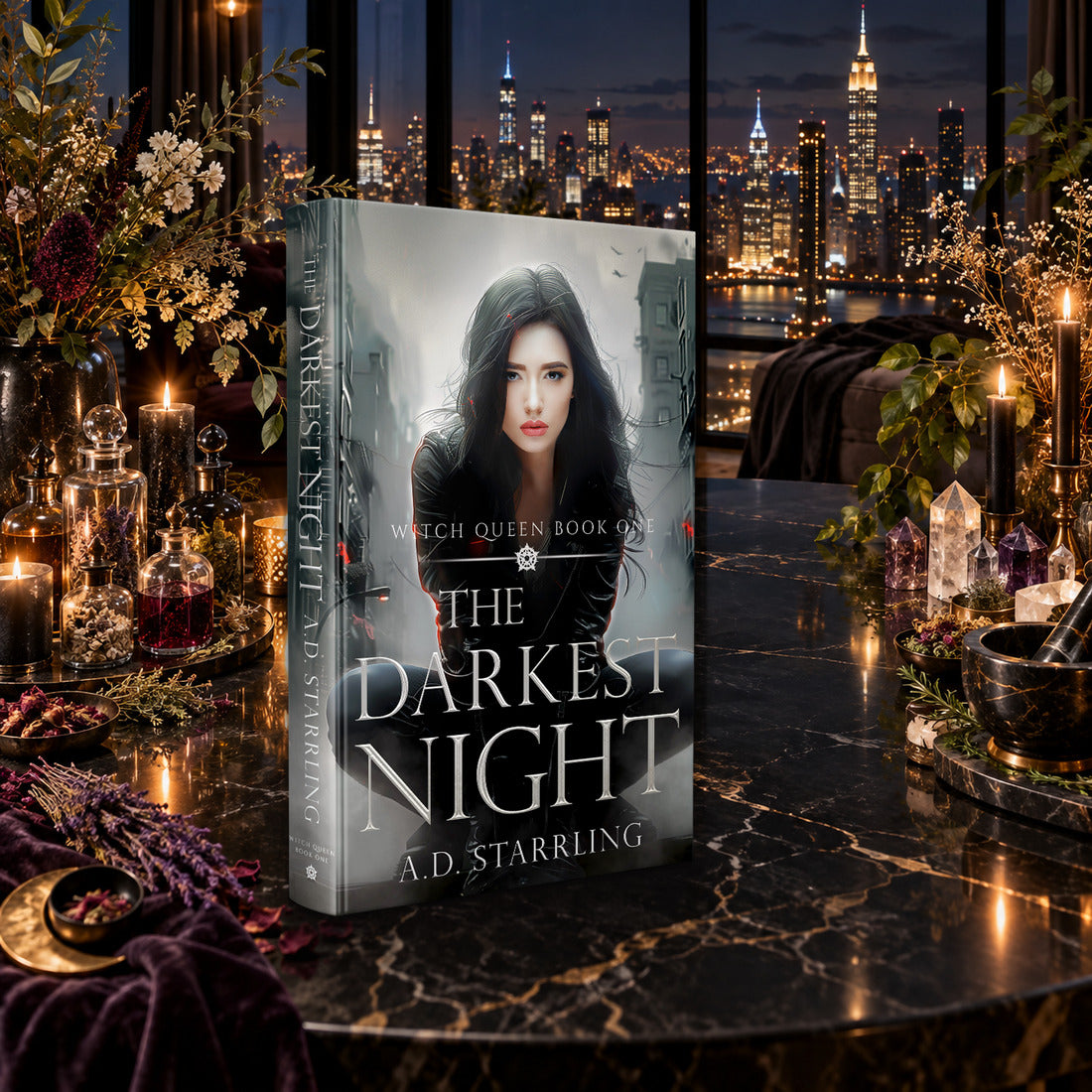 The Darkest Night (Witch Queen Book 1) Hardback by A.D. Starrling on a marble table among crystals and candles with the New York skyline at night