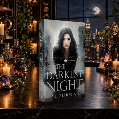 The Darkest Night (Witch Queen Book 1) Paperback by A.D. Starrling on a marble table by a moonlit window over the New York skyline
